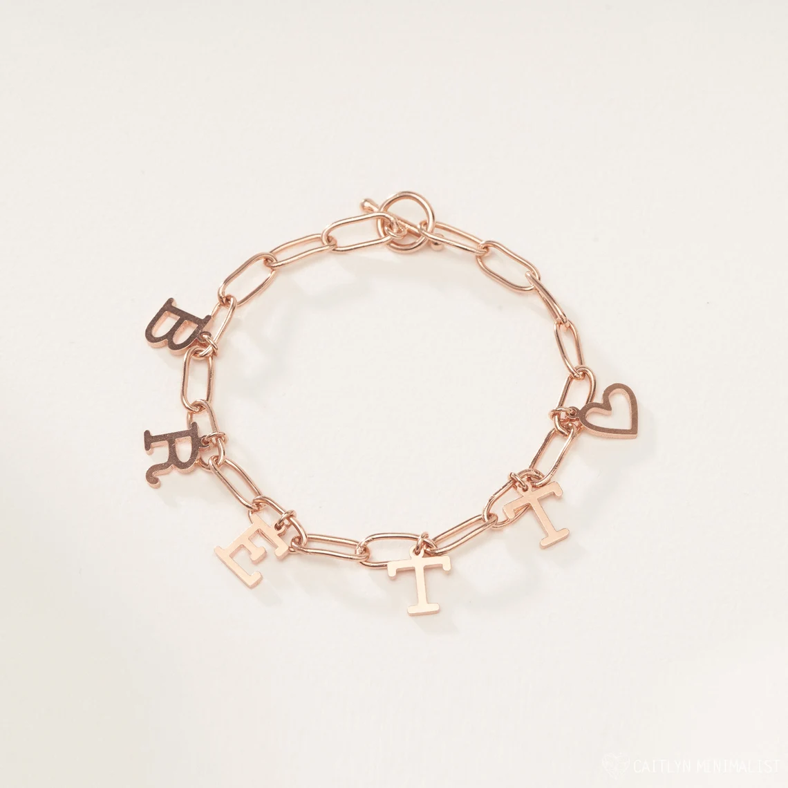 Sterling Silver Initial Bracelet | Rose Gold on White Surface